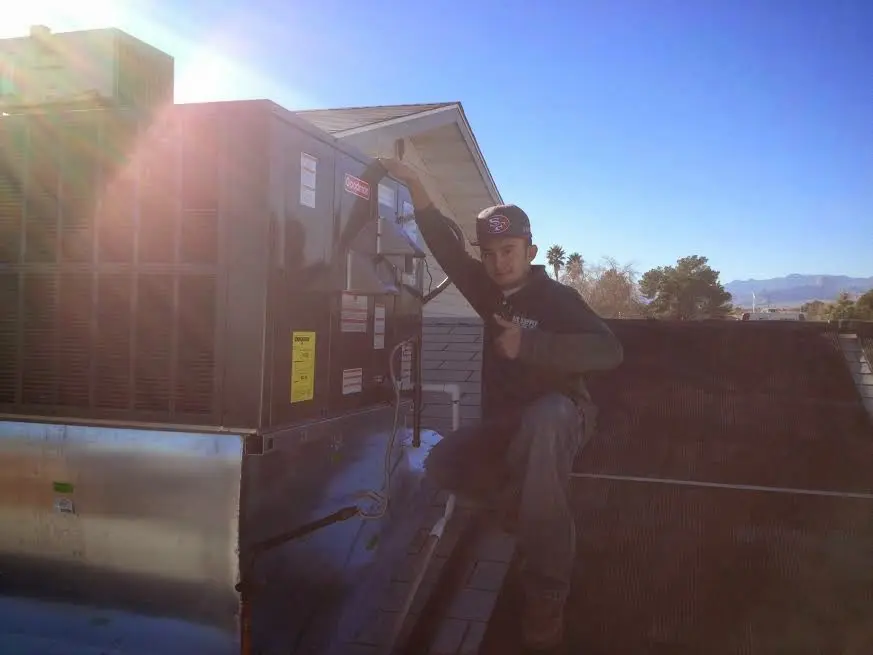 HVAC technician performing AC Tune-Up on a rooftop unit in Lemoore Station